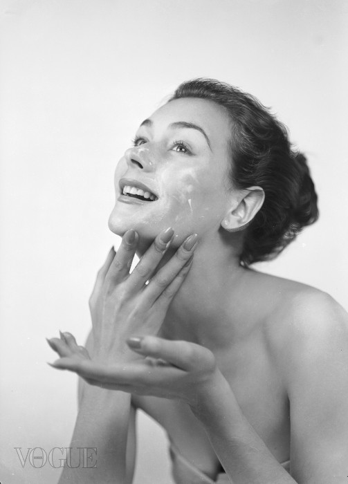 17th June 1952:  A woman applies cream to her face and neck.  (Photo by Chaloner Woods/Getty Images)
