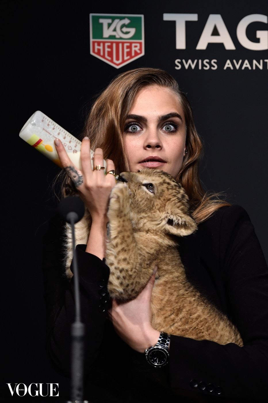 PARIS, FRANCE - JANUARY 23:  Model Cara Delevingne poses with a baby lion as she joins TAG Heuer as Brand Ambassador to launch the new 2015 campaign at Palais des Beaux-Arts on January 23, 2015 in Paris, France.  (Photo by Pascal Le Segretain/Getty Images for TAG Heuer)
