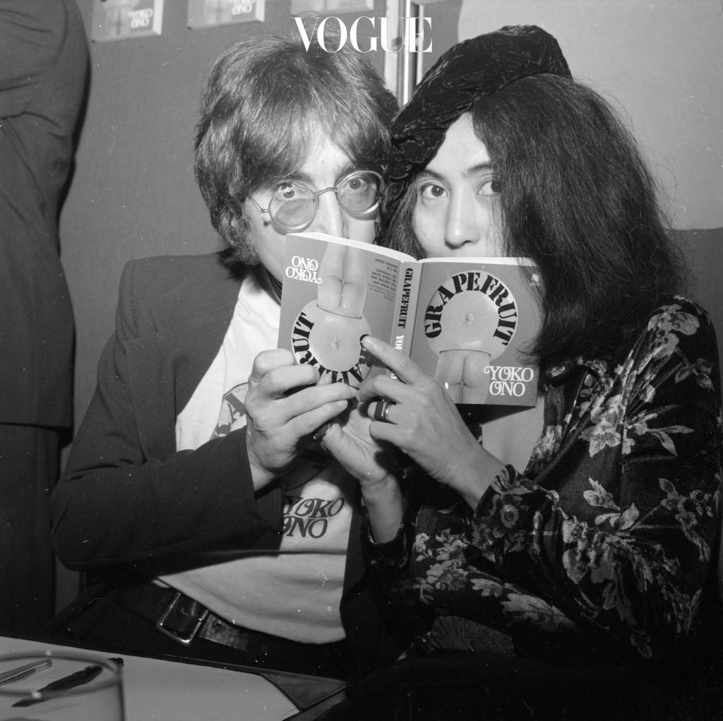 15th July 1971:  Japanese-born artist Yoko Ono and her husband, singer and songwriter John Lennon (1940 - 1980), posing behind a copy of Ono's newly-published photography book 'Grapefruit' at a book signing session at Selfridge's department store, London.  (Photo by Central Press/Getty Images)