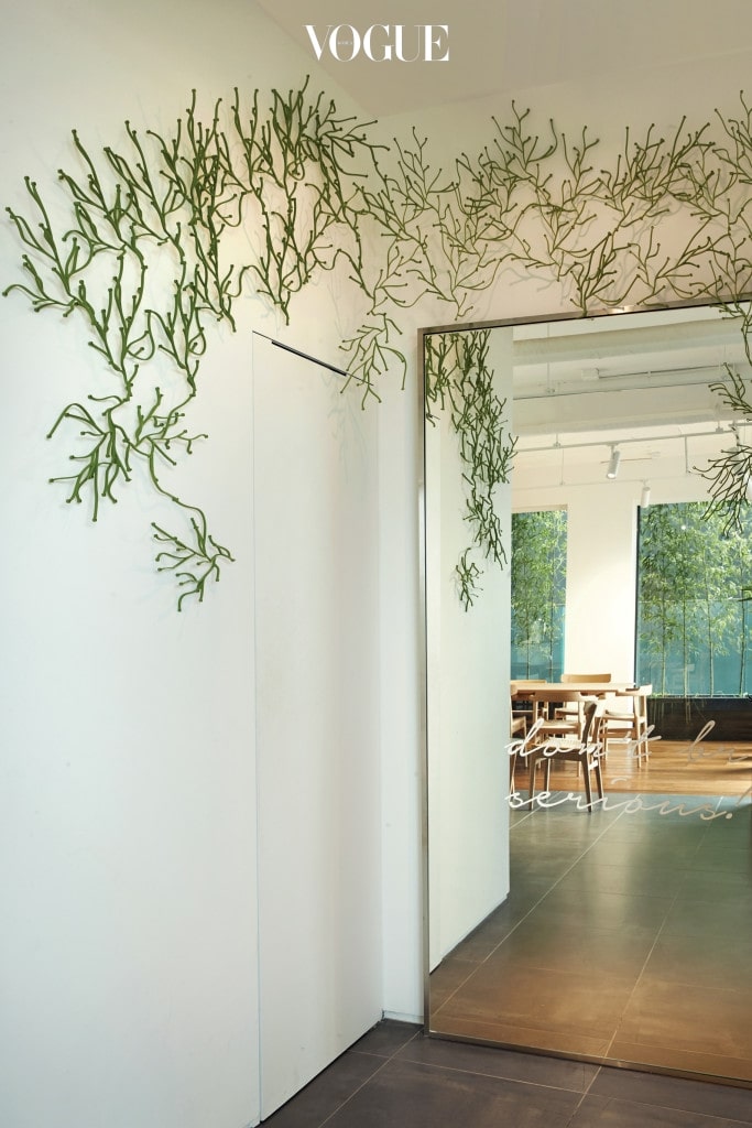한스 J. 웨그너(Hans J. Wegner)의 다이닝 테이블과 의자가 자리한 카페 한쪽 1층 탈의실 공간을 장식한 식물 스타일링.