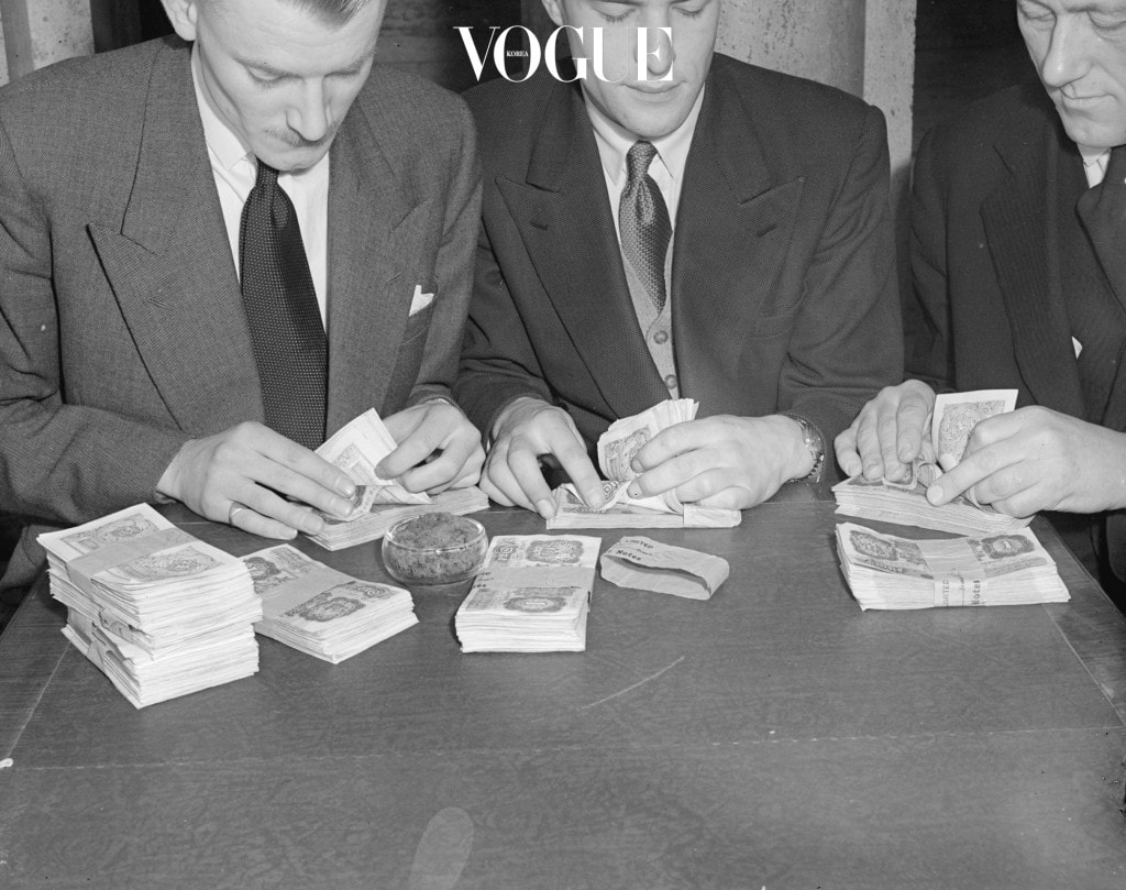 6th February 1952:  Businessmen counting banknotes.  (Photo by Harold Clements/Express/Getty Images)