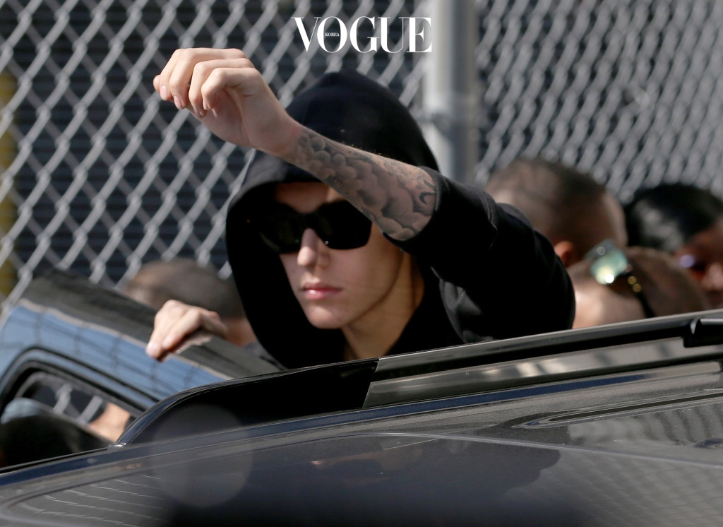 MIAMI, FL - JANUARY 23:  Justin Bieber prepares to stand on his vehicle after exiting from the Turner Guilford Knight Correctional Center on January 23, 2014 in Miami, Florida. Justin Bieber was charged with drunken driving, resisting arrest and driving without a valid license after Miami Beach police found the pop star street racing Thursday morning.  (Photo by Joe Raedle/Getty Images)