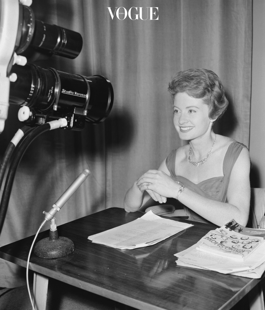 Sheila Tracy (1934 - 2014) in front of TV cameras at the Radio Show, where she is working as announcer and interviewer, Earls Court, London, 24th August 1961. She is wearing a diamond set, of ring, watch and necklace, worth ten thousand pounds, on loan from London diamond merchant Michael Feld. Tracy went on to a career presenting and newsreading on BBC television and radio. (Photo by John Franks/Keystone/Hulton Archive/Getty Images)